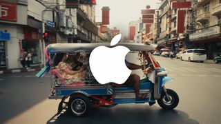 Apple logo over a screenshot from Apple&#039;s Thailand ad featuring a tuktuk