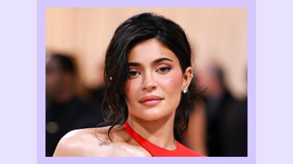 Kylie Jenner wears a red dress, with her hair up as she attends The 2023 Met Gala Celebrating "Karl Lagerfeld: A Line Of Beauty" at The Metropolitan Museum of Art on May 01, 2023 in New York City. / in a purple template