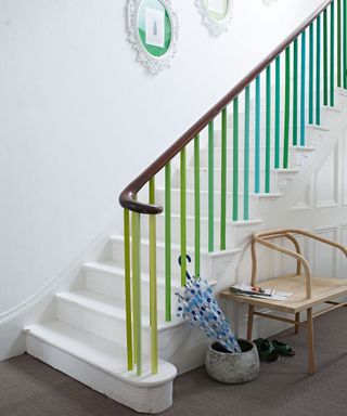 hallway with staircase having painted banisters