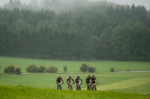 The lead group pedals through the fog