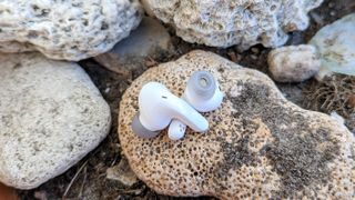 LG Tone Free T90 earbuds placed on rocks