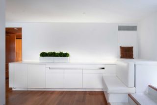 All white living and storage area in micro apartment