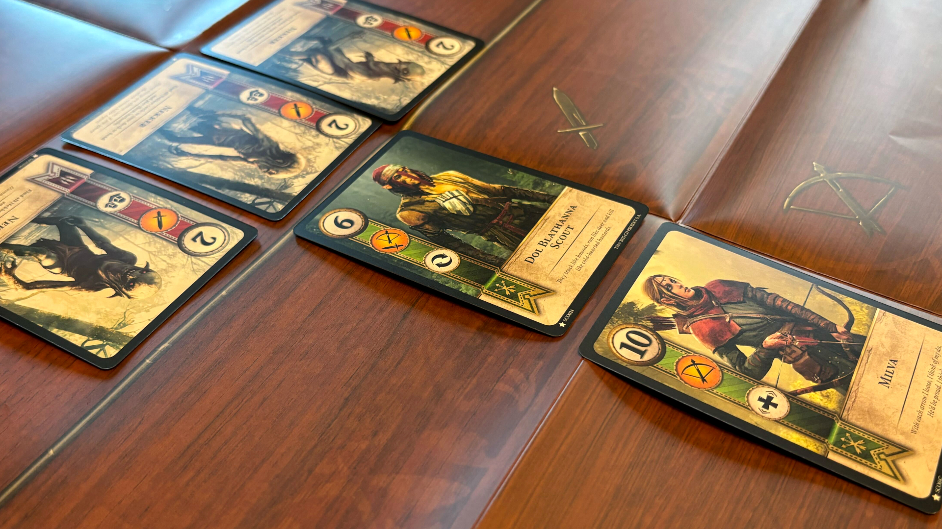 A T-shaped arrangement of Gwent cards on a wood-effect surface