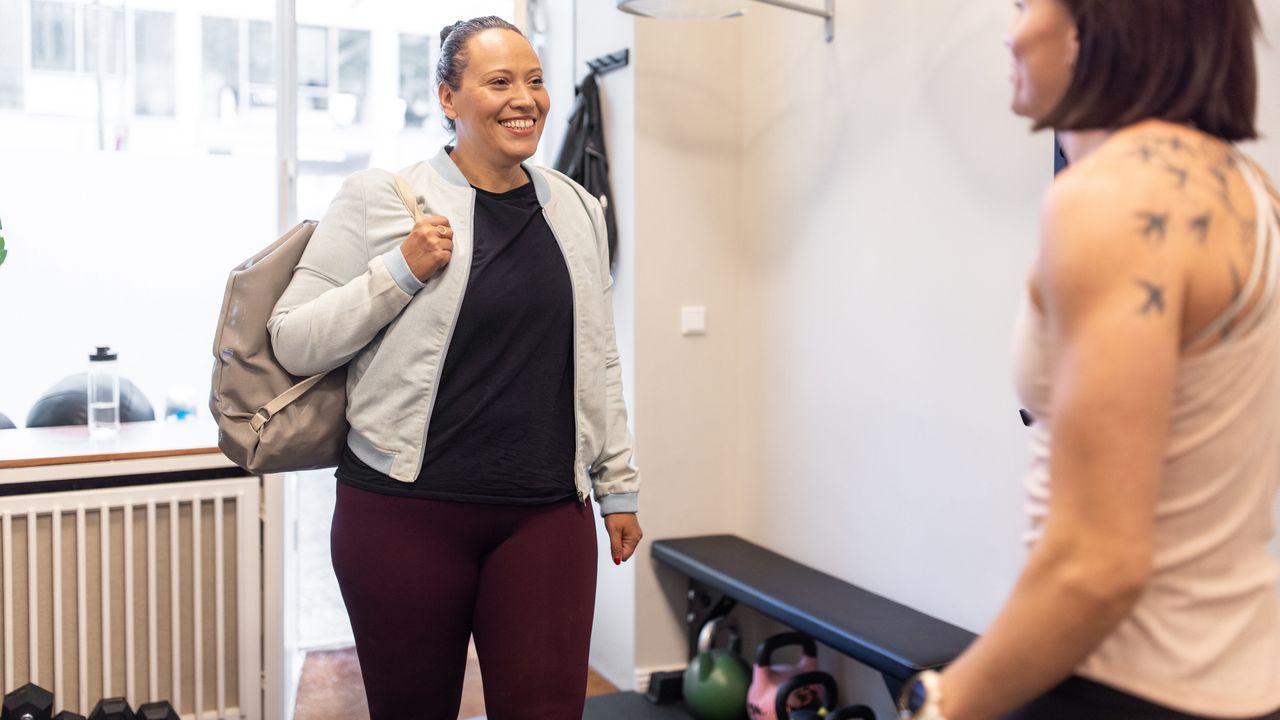 Smiling woman enters gym