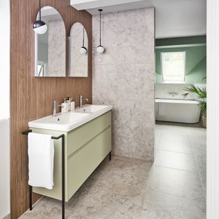 a double basin vanity unit with double mirrors and ceiling hung pendant lights