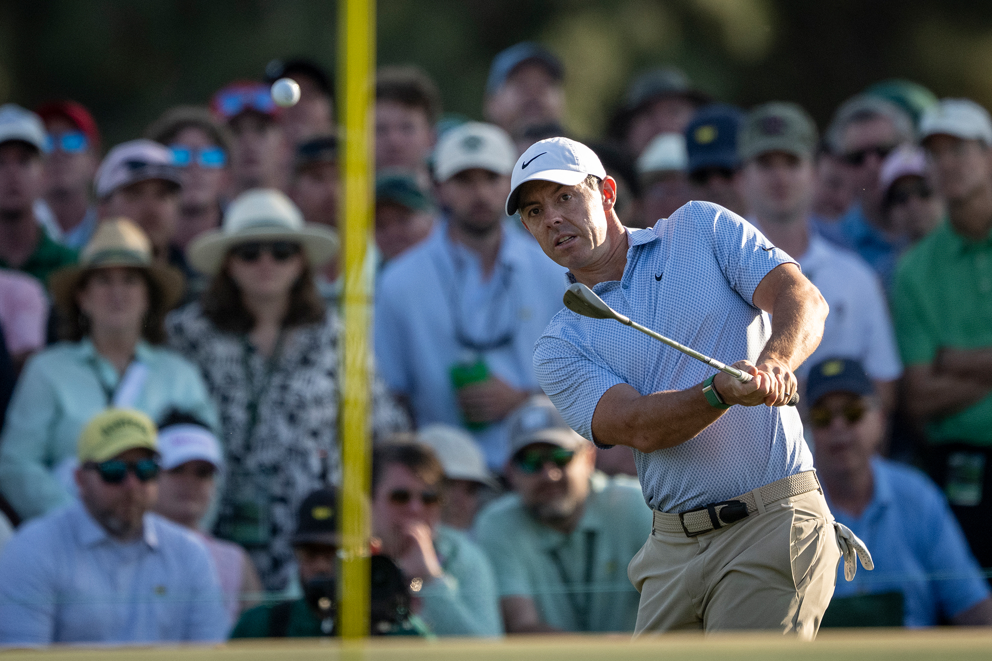 Rory McIlroy in the finish position watching his ball in flight after hitting a chip shot at The Masters
