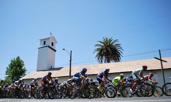 The peloton passes a church during the Vuelta a Chile