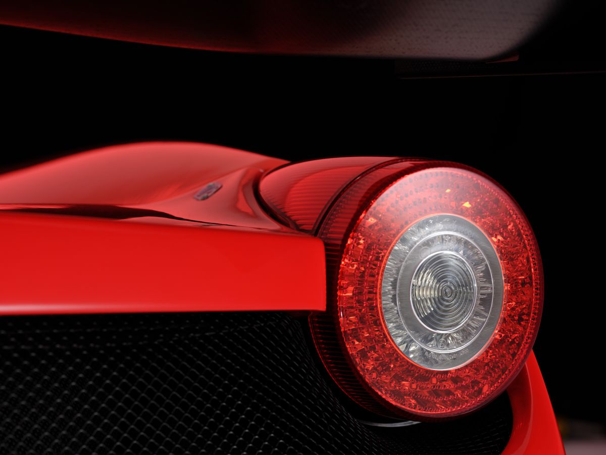 A red Ferrari 458 car in a studio