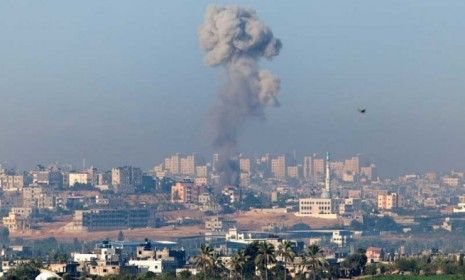 A plume of smoke rises over Gaza during an Israeli air strike, as seen from Sderot in Israel.
