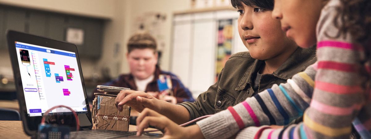 Boy and girl use laptop computer.