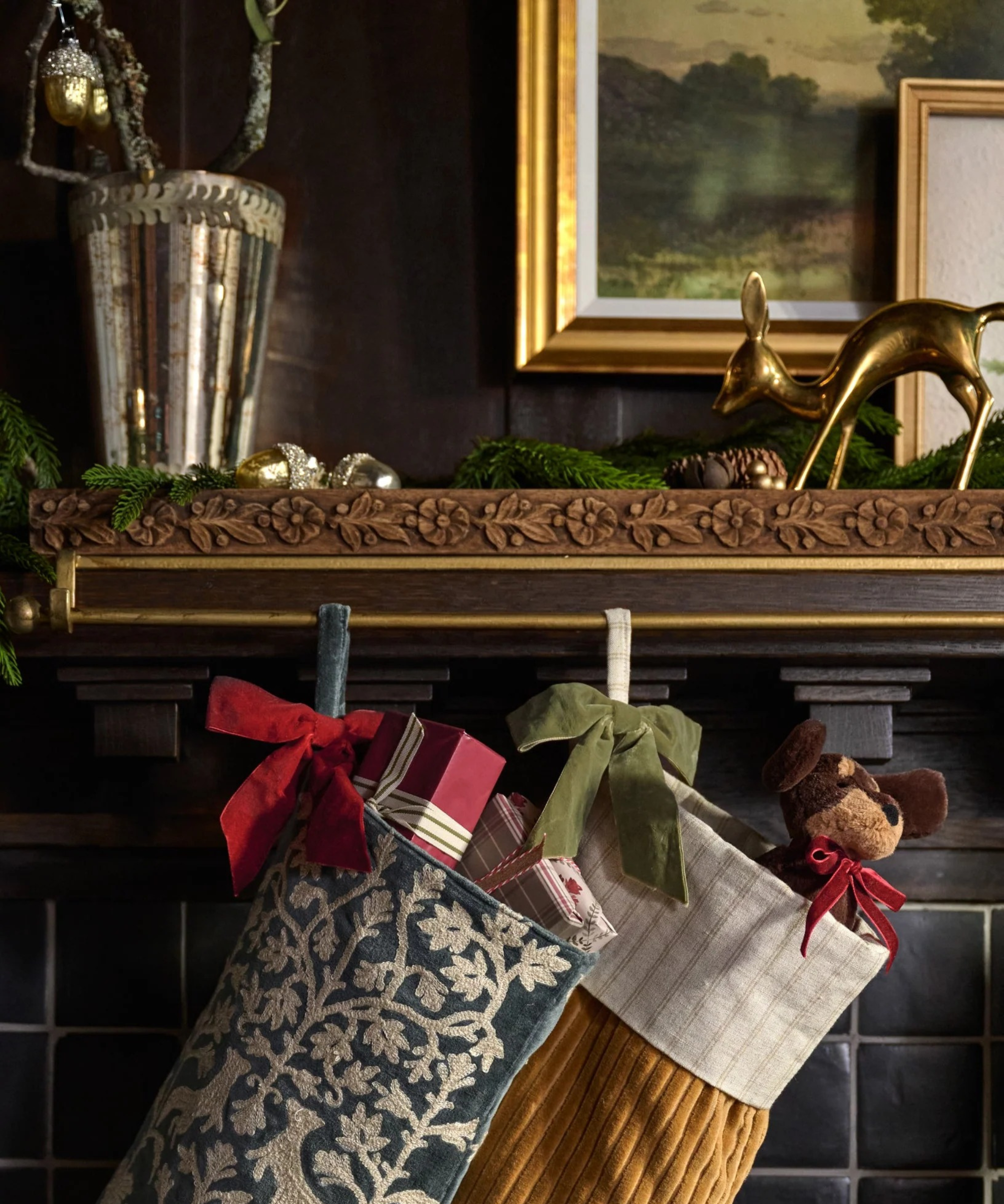 a mantel with stockings hanging from a brass stocking holder