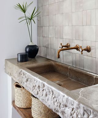 Rustic bathroom with stone basin and tiled wall