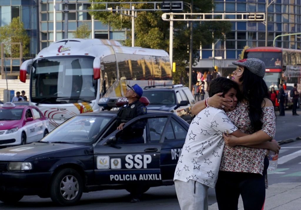 A woman embraces a boy as a powerful earthquake rocks Mexico City on February 16, 2018.