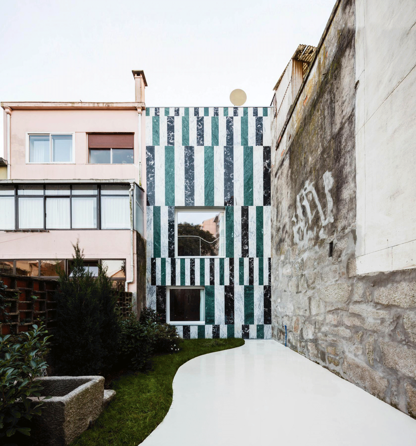 Thin house with green striped exterior and modern interior