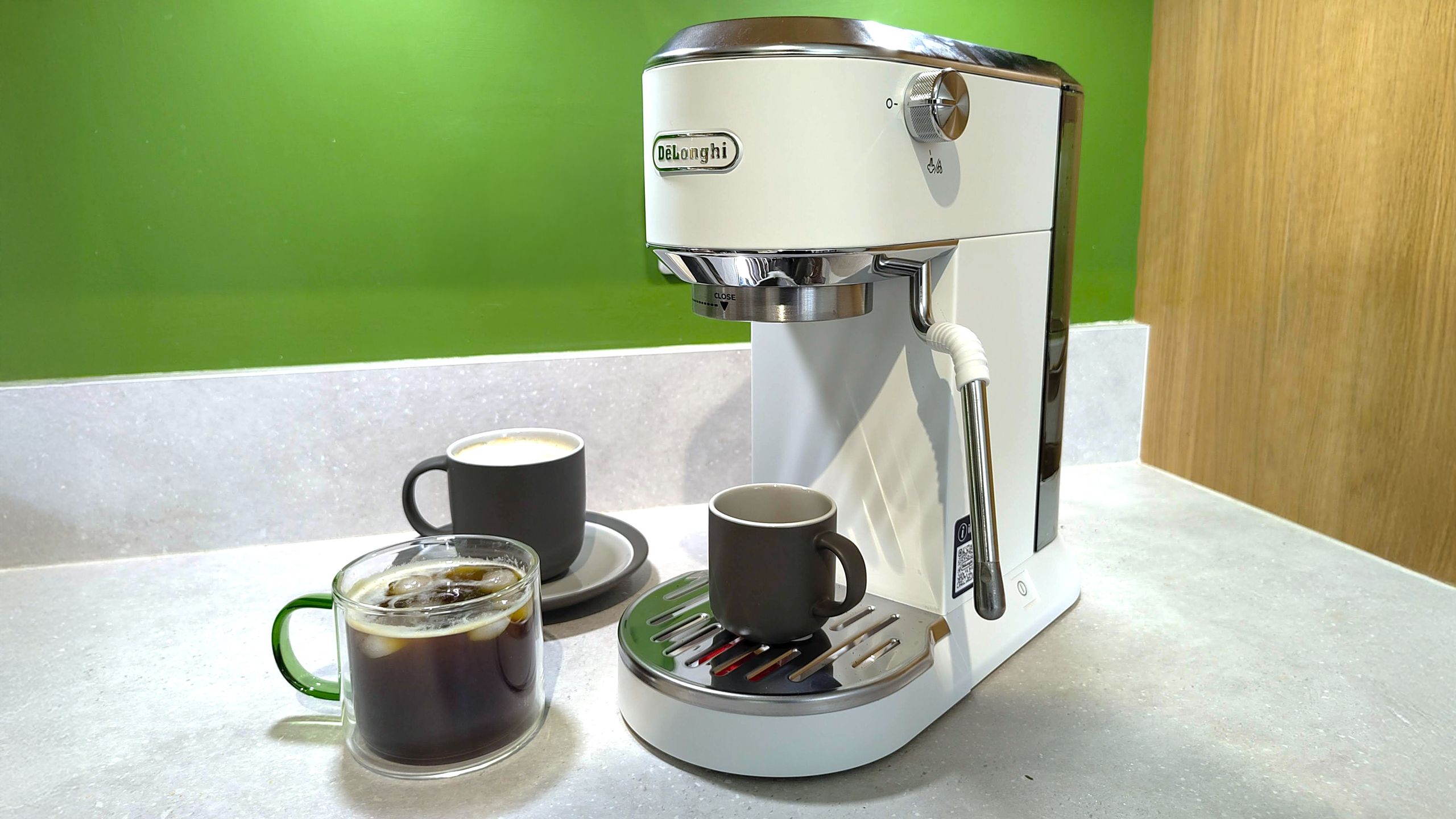 DeLonghi Dedica Duo coffee machine on kitchen counter with coffee cups