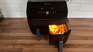 The Instant Vortex Plus Dual Drawer Air Fryer having just been used to cook fries with the right-hand drawer partially removed