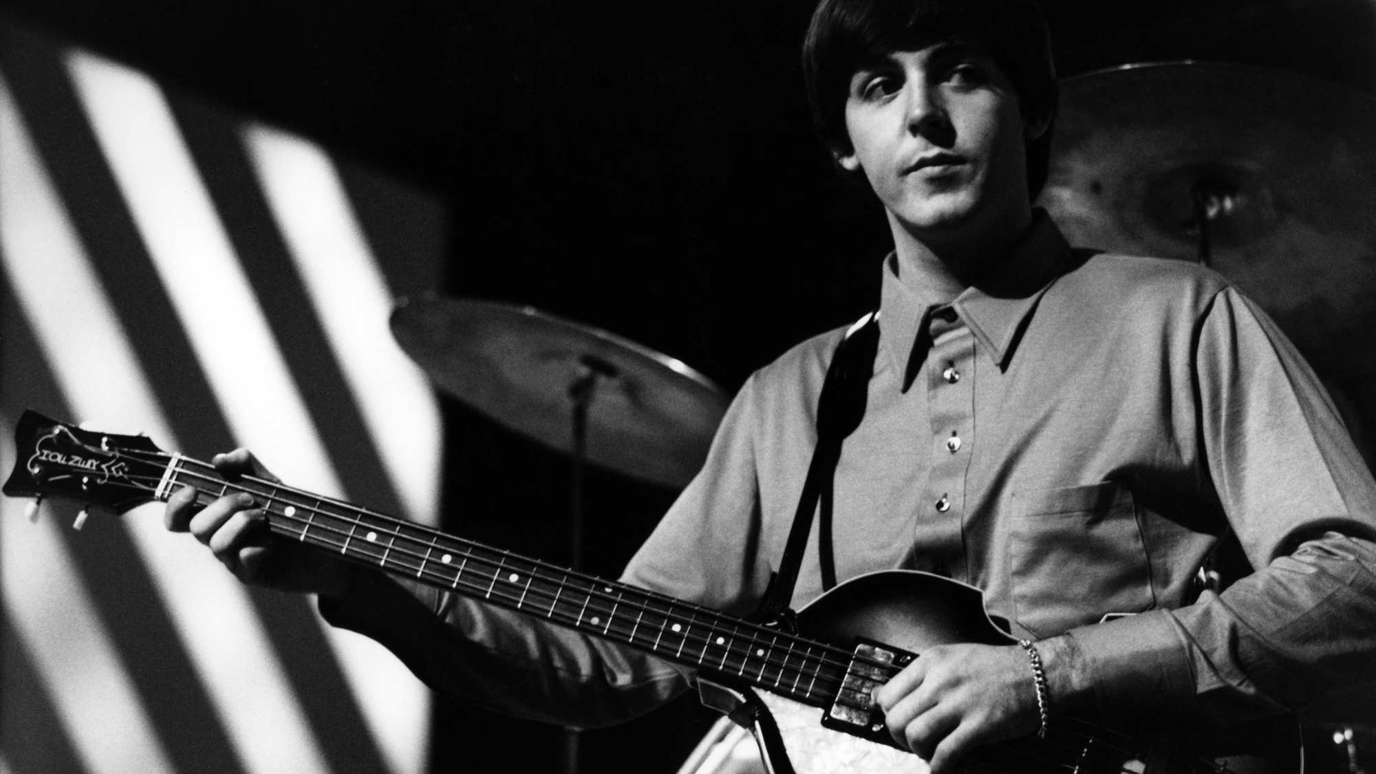 Paul McCartney of English rock and pop group The Beatles plays his Hofner 500/1 violin bass guitar on stage during rehearsals