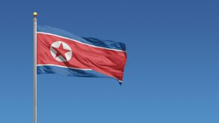 The North Korean flag flying against a clear blue sky