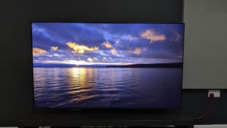 Samsung S95D with sunset and sea on screen