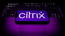 Citrix logo pictured on a smartphone screen placed on top of a laptop keyboard.