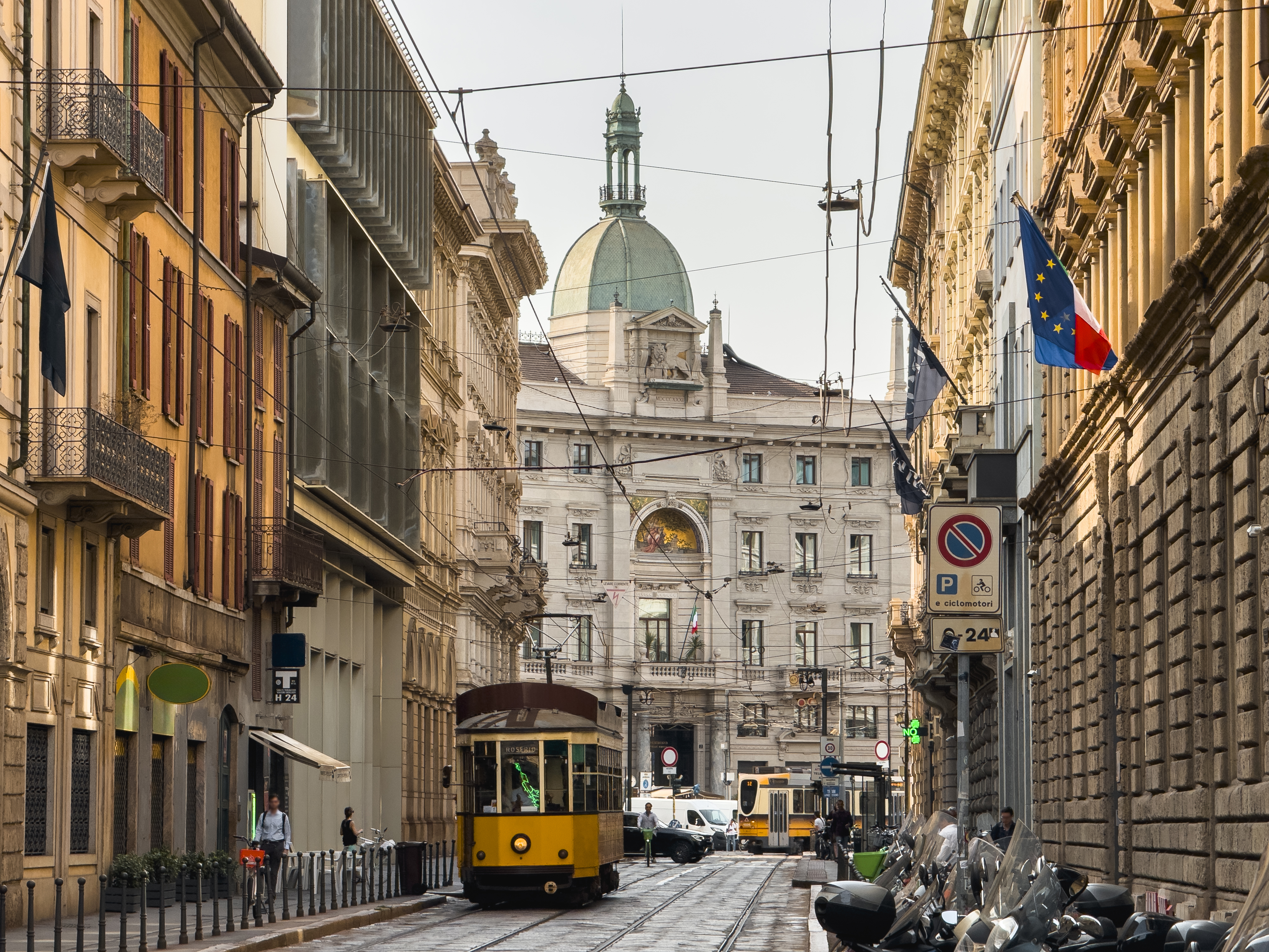 Yellow tram running down the old streets of Milan