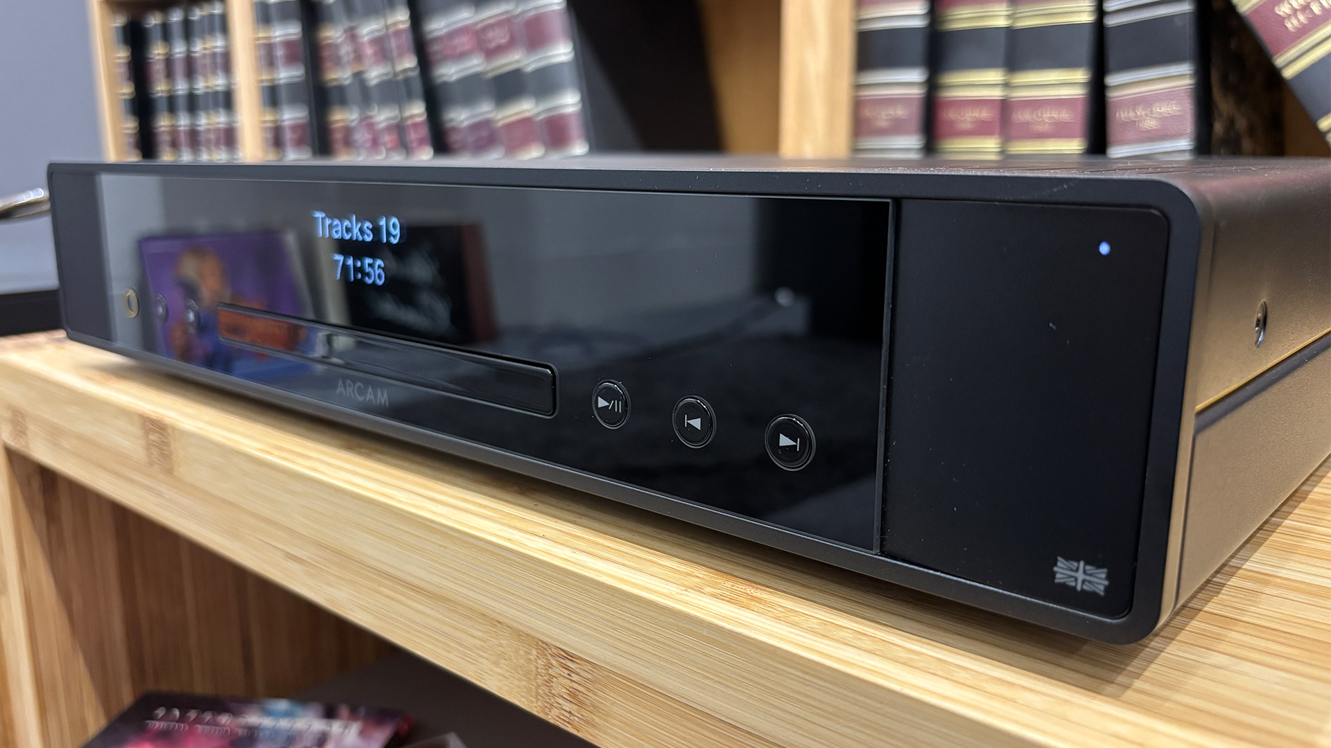 Arcam CD25 CD player on wooden hi-fi rack in front of bookcase