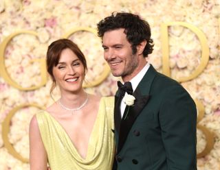 Leighton Meester wearing a lime green gown and Adam Brody smiling wearing a green tux posing on Golden Globes 2025 red carpet