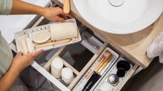 Small bathroom drawers containing makeup accessories organized neatly into sections - for article on how to declutter small bathroom drawers