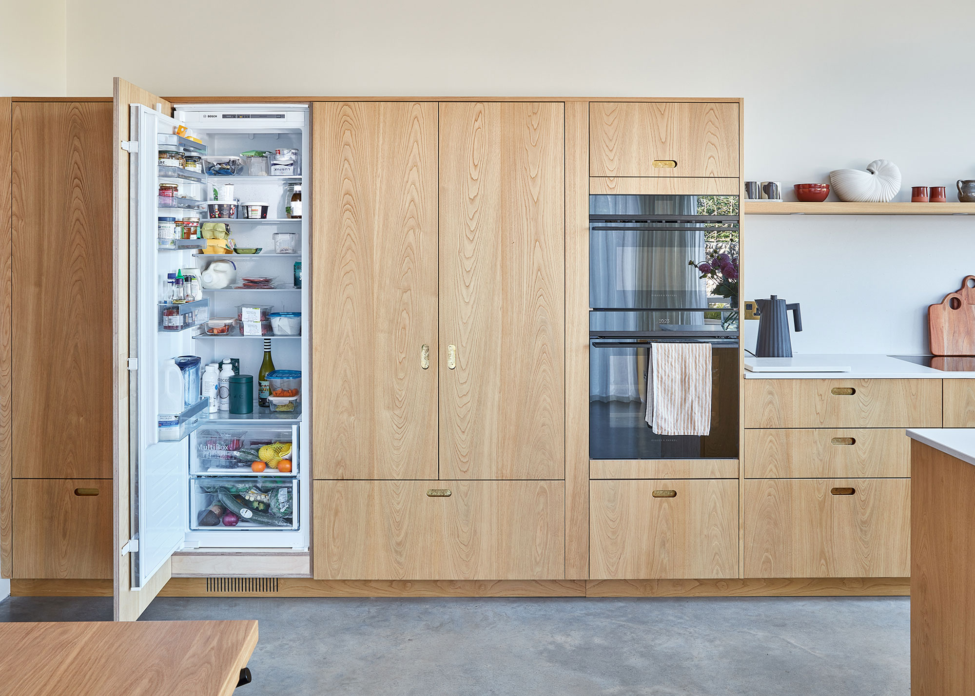 wooden kitchen with integrated fridge and built in ovens