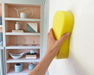 Wiping down wall with a sponge