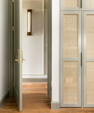 Bedrooms cupboards with a soft green paint color and a mix of black and gold hardware