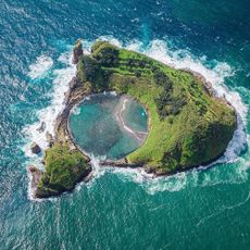 A green, sunny island, in the middle of a blue ocean.