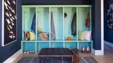 mudroom with blue storage unit with stalls, foot stool and storage shelf - Andrea Schumacher