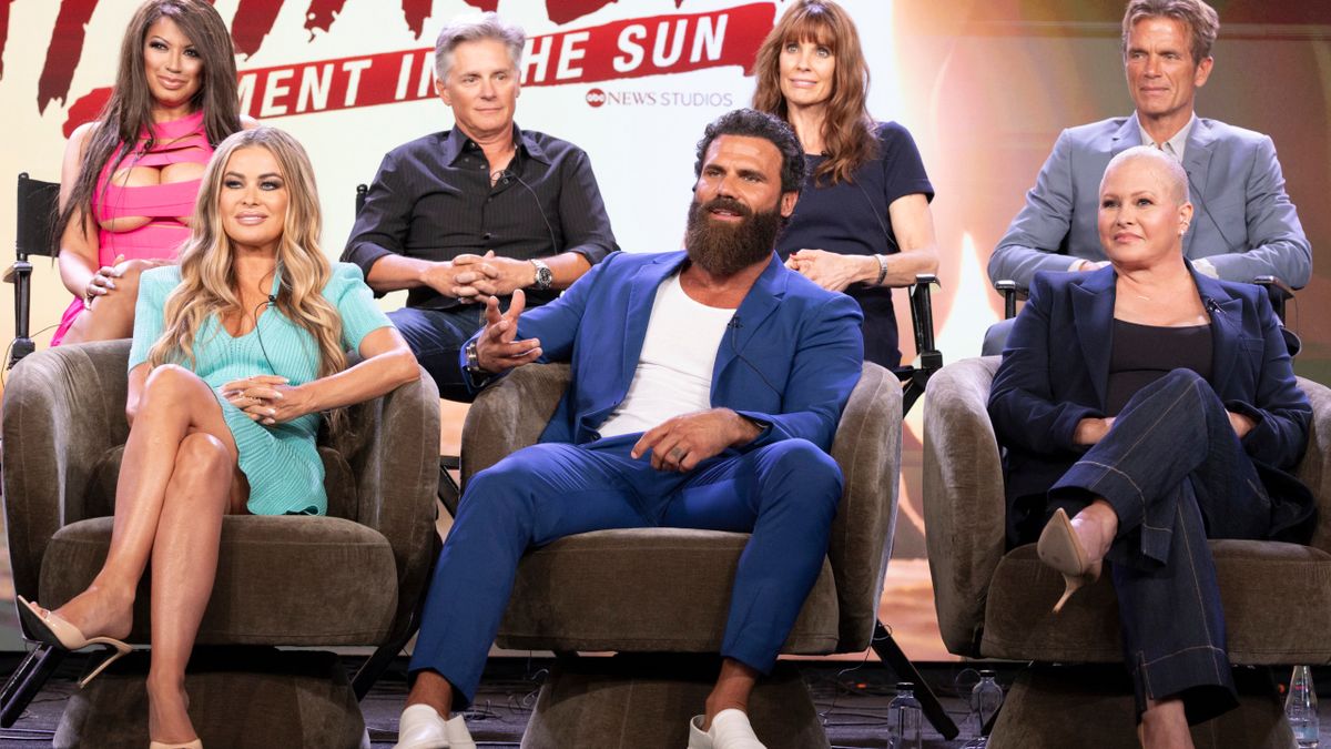 Members of the Baywatch cast sit together on stage during a reunion for a panel on After Baywatch: Moment in the Sun.