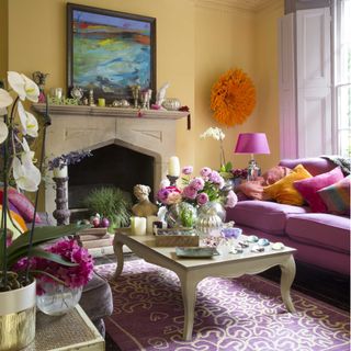 Yellow room, pink sofa, wall mounted orange feathered headdress