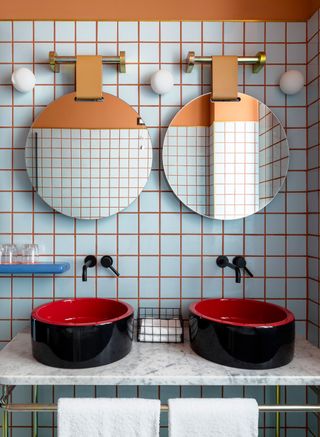 a bathroom with blue tiles and orange grout
