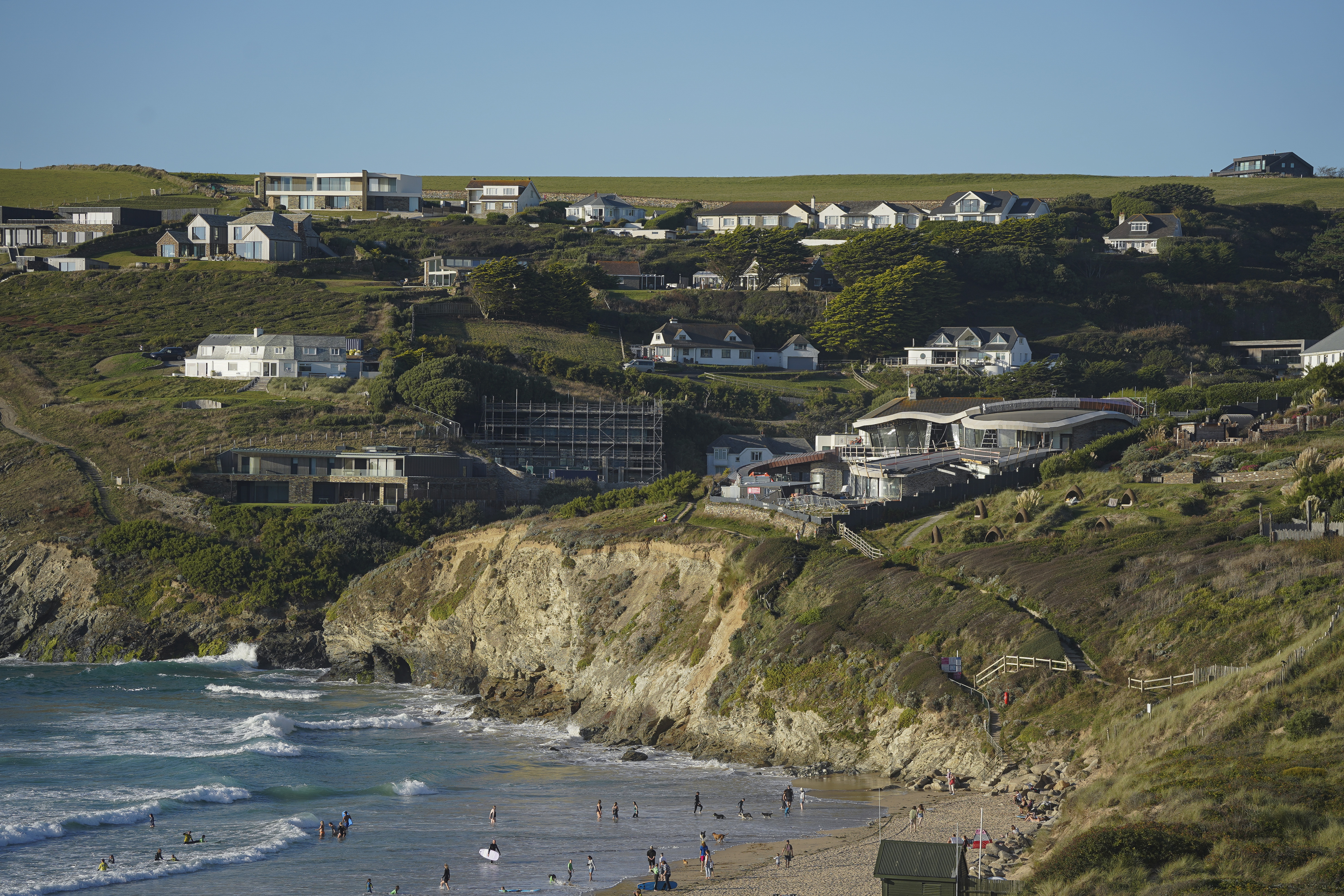 Extensive new building works and other recent new builds dominate the coast above the beach at Mawgan Porth, near Newquay.