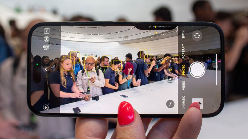 iPhone 16 smartphone held in hand in landscape showing people in camera mode in Apple Store