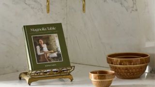 The Magnolia cookbook on a stand with their mixing bowls to the right hand side