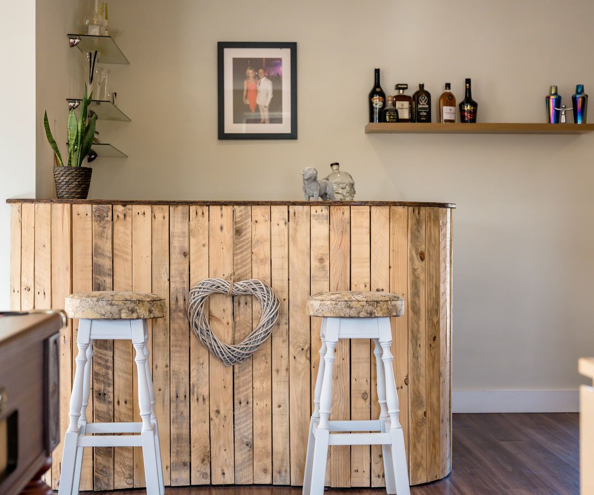 A wooden bar next to a pool table in a games room