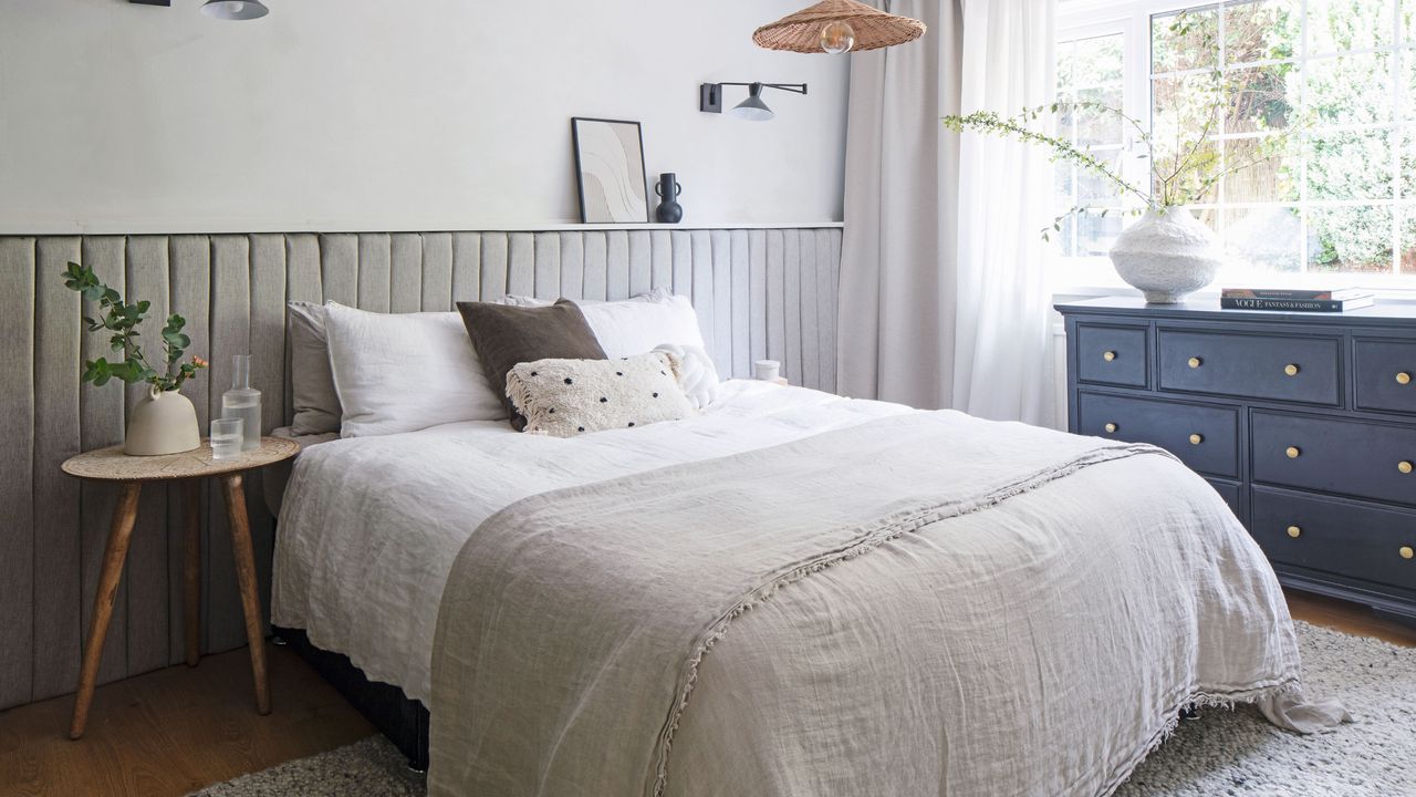 Neutral bedroom colour scheme with double bed, chest of drawers, and rug underneath bed