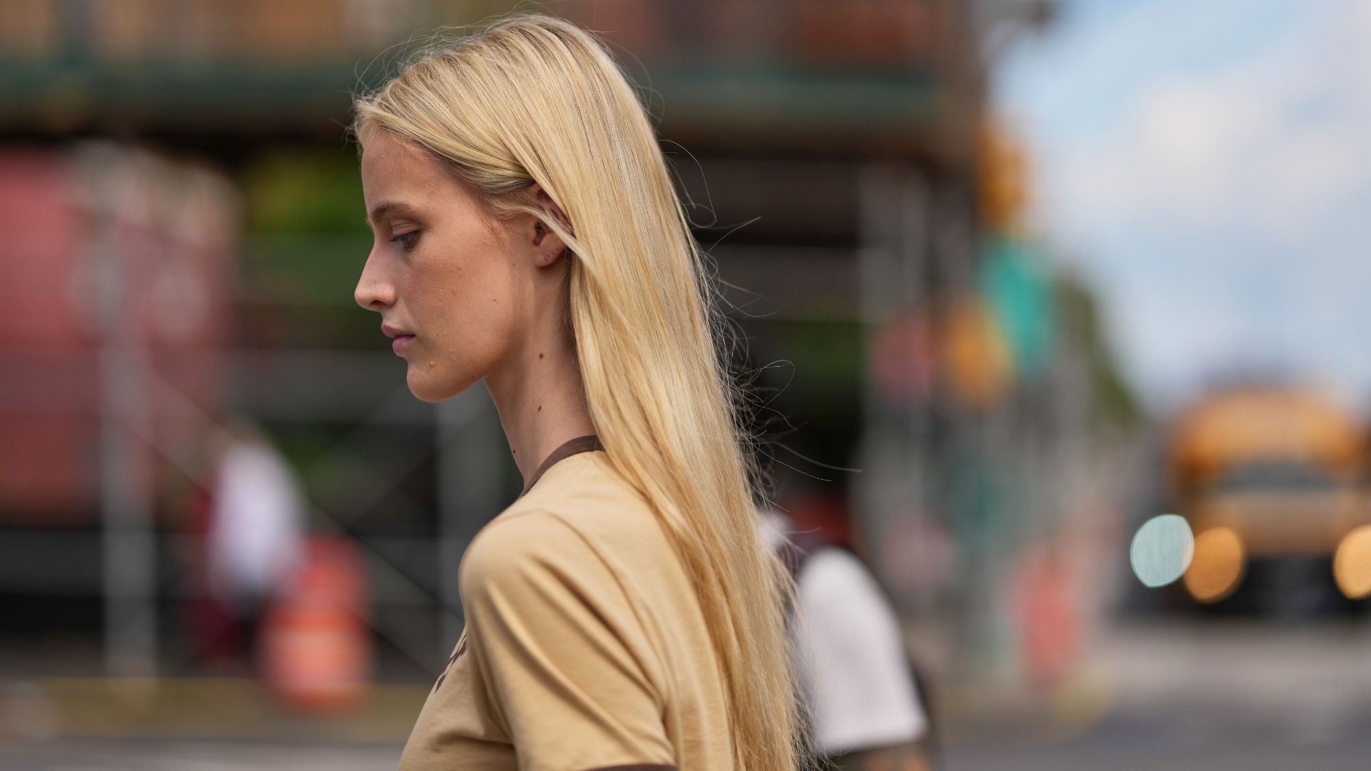 Woman with glossy blonde hair walking down the street