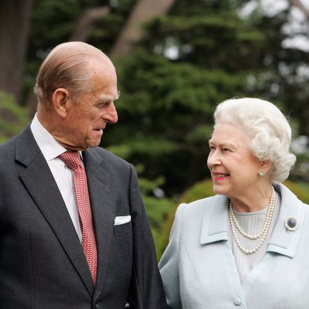 Queen Elizabeth and Prince Philip smiling at each other in an anniversary portrait 