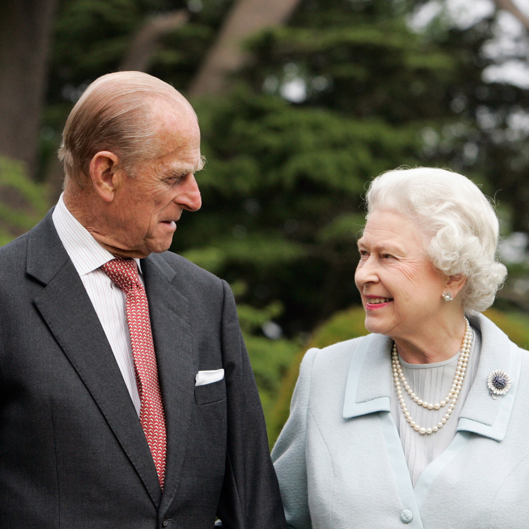Queen Elizabeth and Prince Philip smiling at each other in an anniversary portrait 