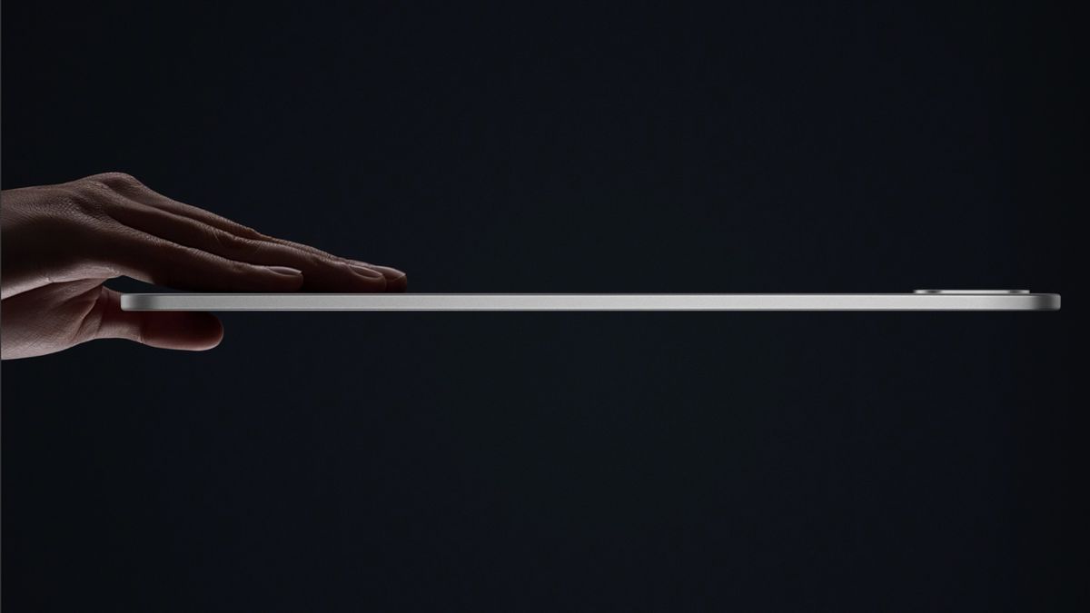 OnePlus Pad 3 product image of hand holding tablet side on to show how thin it is on black background