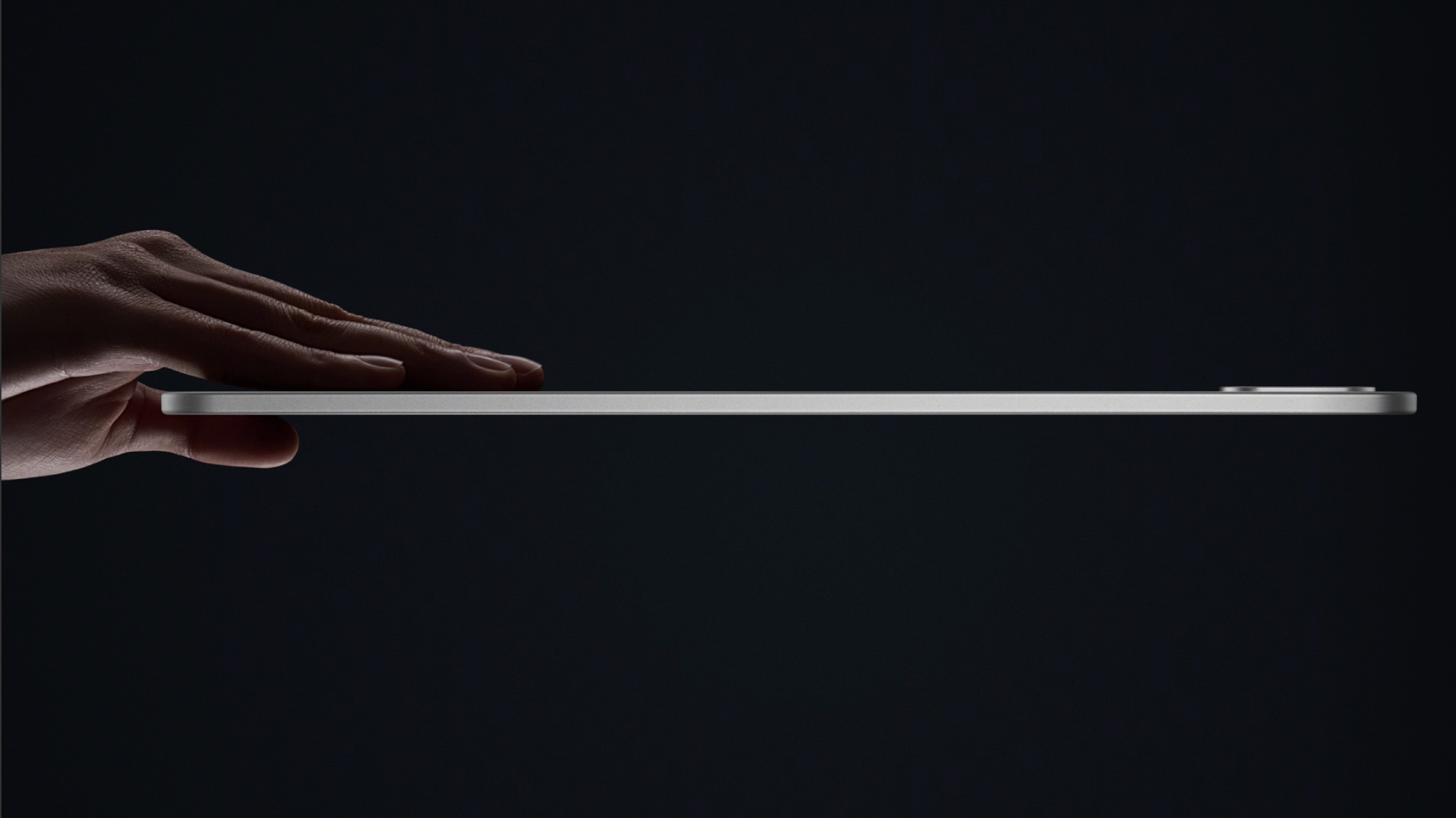OnePlus Pad 3 product image of hand holding tablet side on to show how thin it is on black background