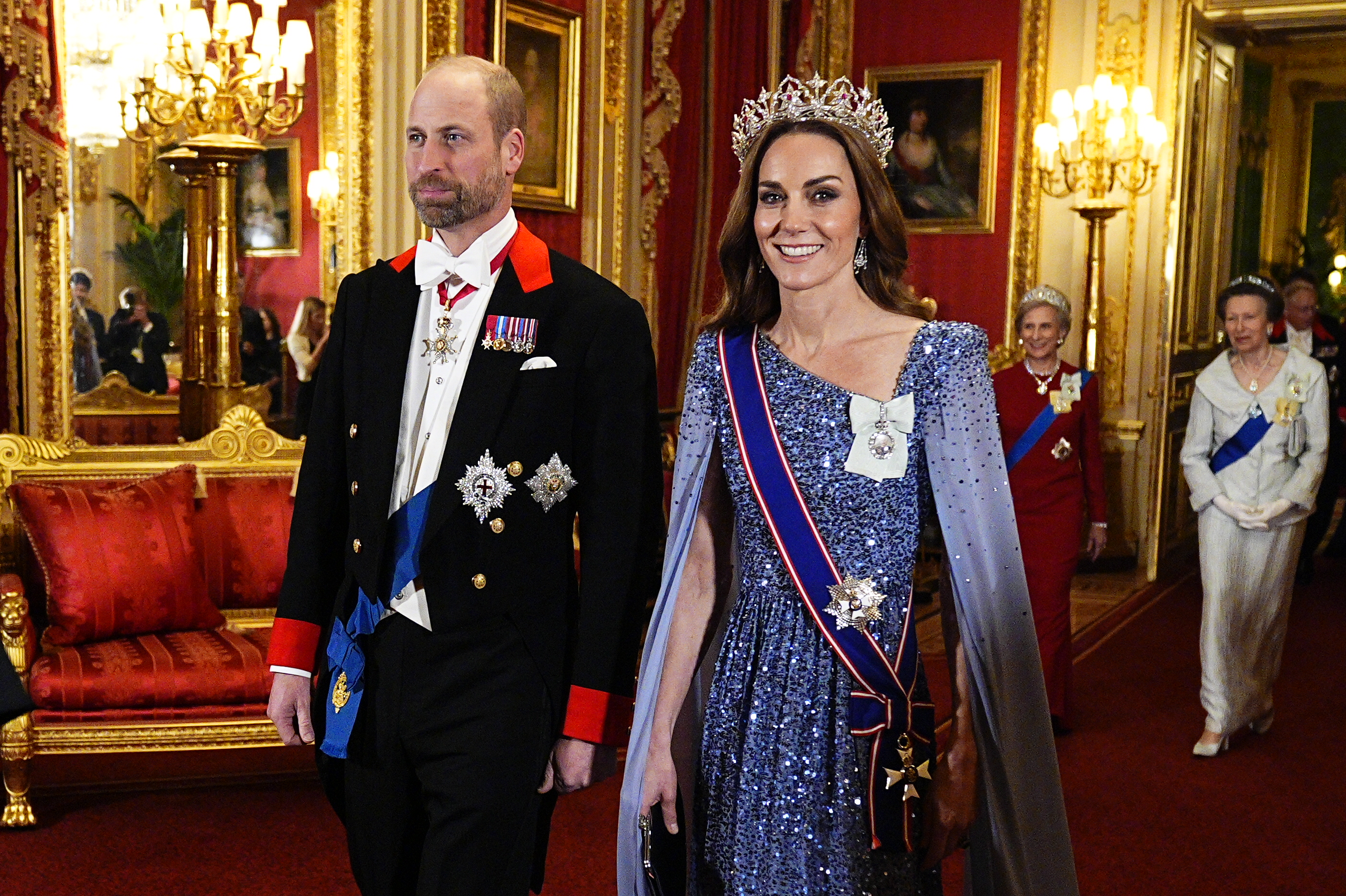 Kate Middleton wearing a blue sequin gown and tiara walking with Prince William at a banquet