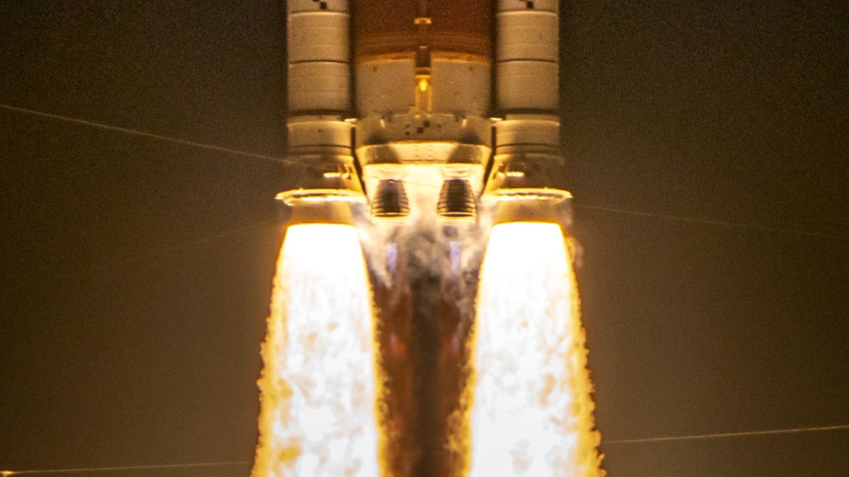 two massive side booster spew yellow orange fire lifting the core stage of a rocket as two main engines also ignite 