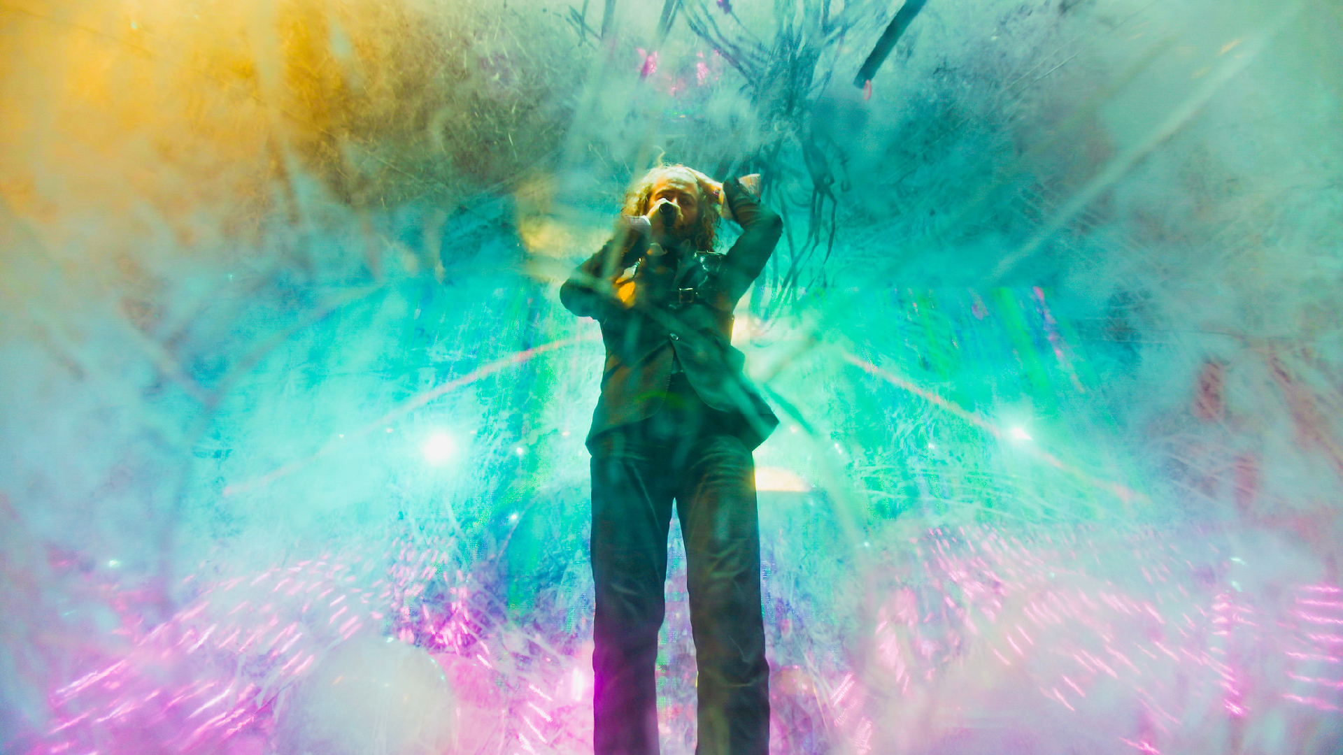 Wayne Coyne, frontman of The Flaming Lips, on a psychedelic multi-coloured background