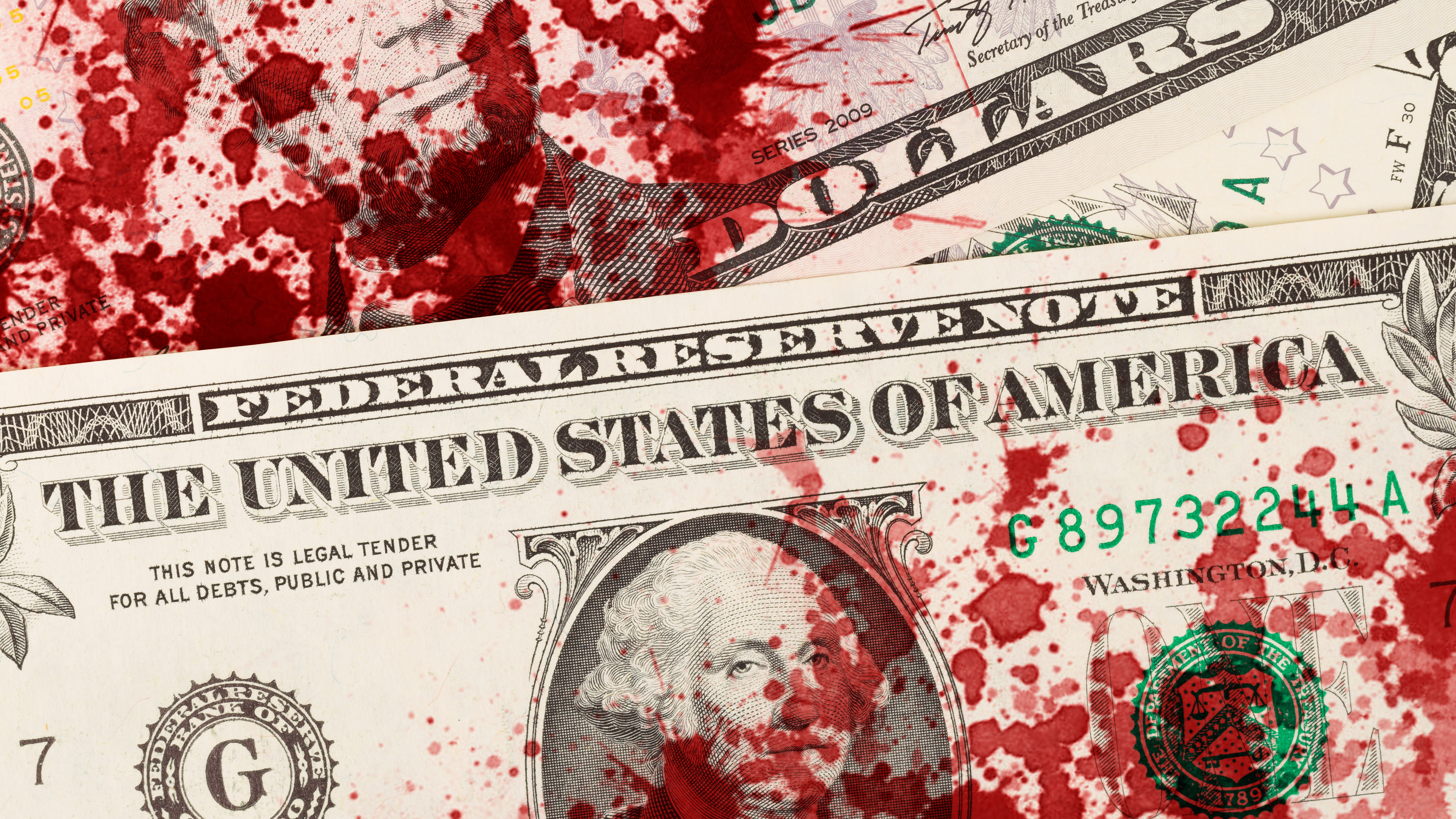 Close-up of US dollar bills spattered with red blood